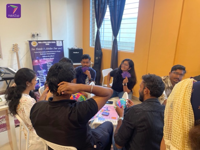 A family laughing while playing the HabitZup card game.